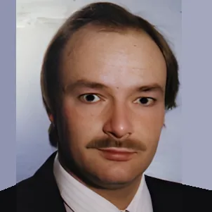 Profilbild, braune Haare, braune Augen, Schnauzer, weißes Hemd, schwarzes Jackett, blauer Hintergrund