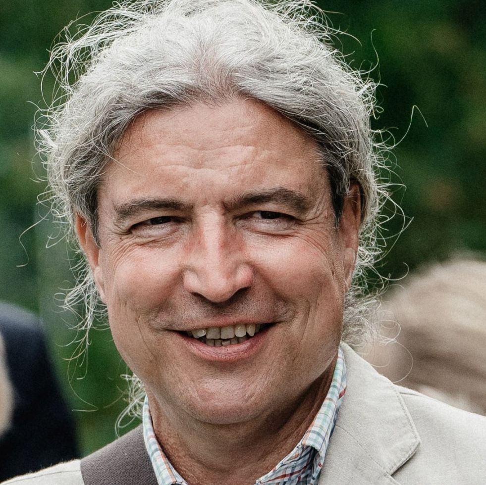 Profilfoto von Carsten Bolz, graue Haare, lächelnd, Hemd und Anzug tragend